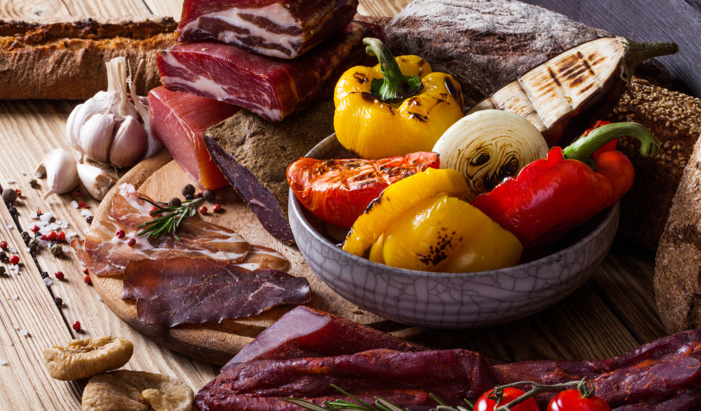 Мясные продукты на столе с запеченными овощами