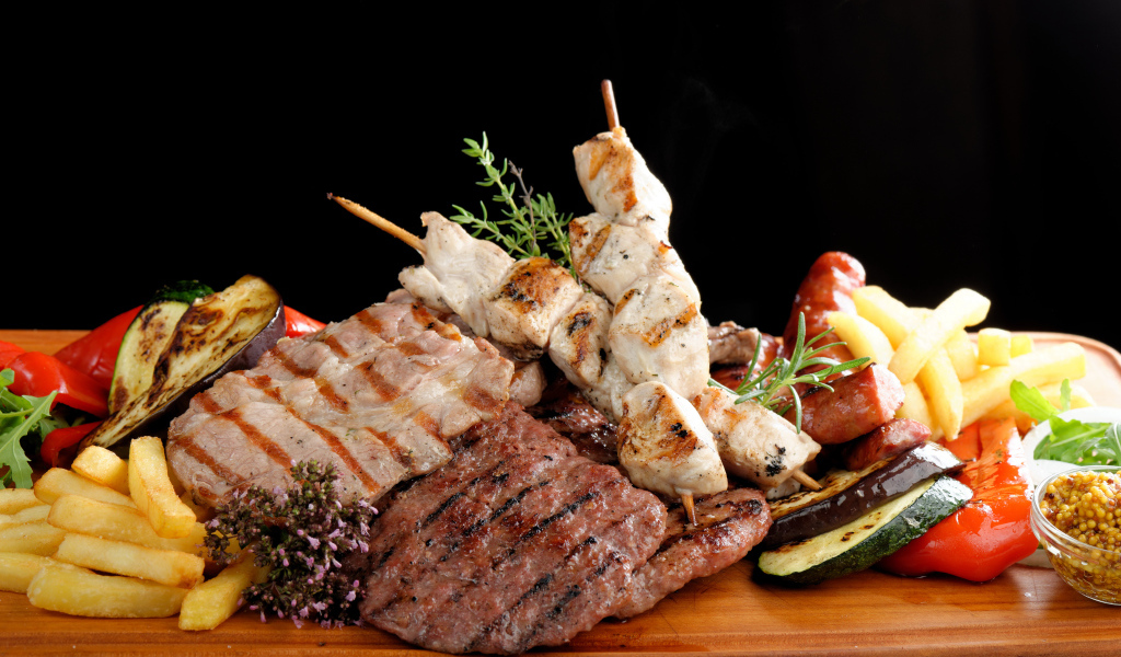 Мясные продукты на столе с картофелем фри 