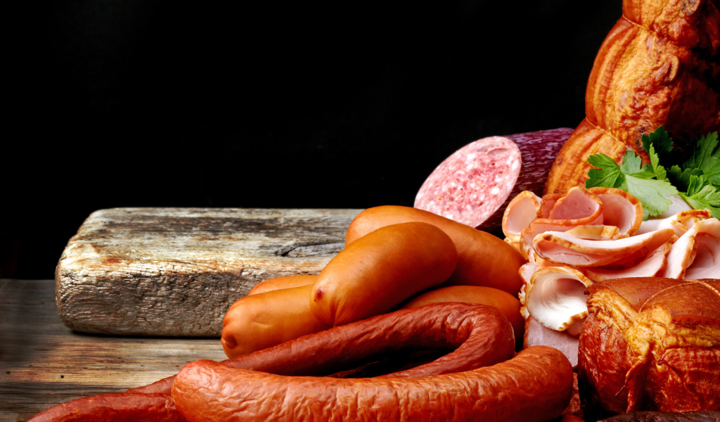 Колбаса с ветчиной лежат на столе