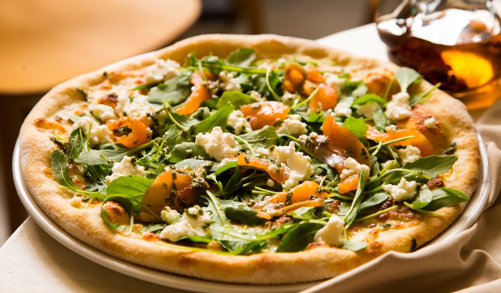 Аппетитная пицца с рыбой и зеленью на столе