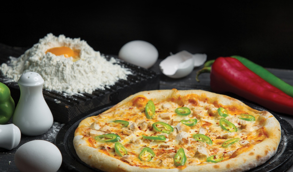 Пицца на столе с яйцами и перцем