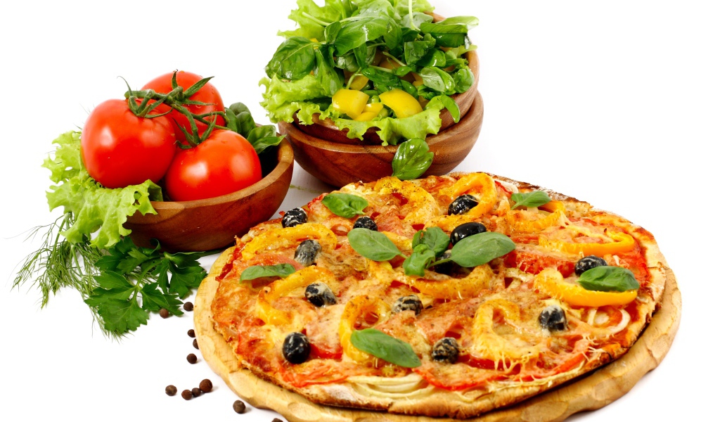 Пицца на столе с овощами и зеленью на белом фоне