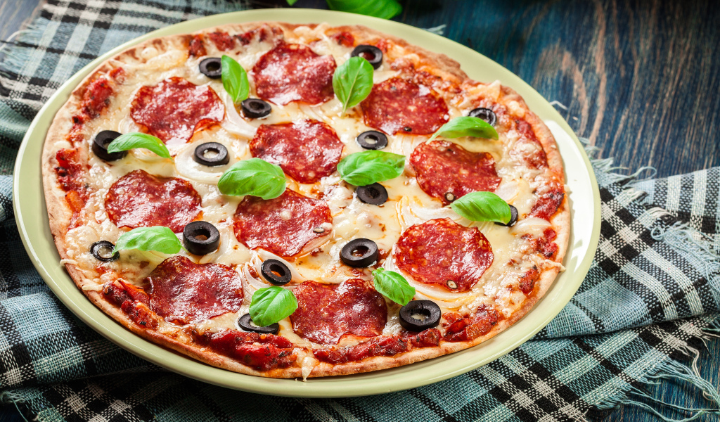 Пицца с сыром и салями на столе 