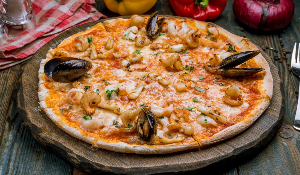 Вкусная пицца с морепродуктами на деревянной доске