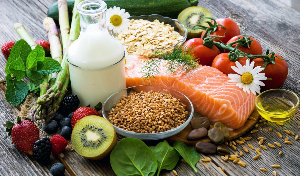 Кусок красной рыбы на столе с ягодами и овощами