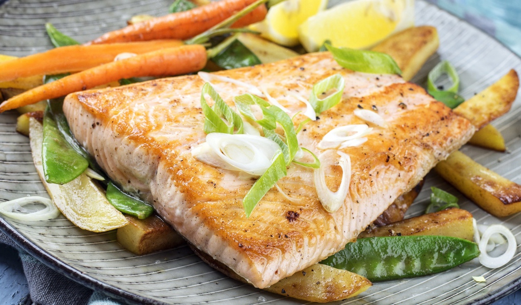 Запеченная красная рыба с овощами на тарелке