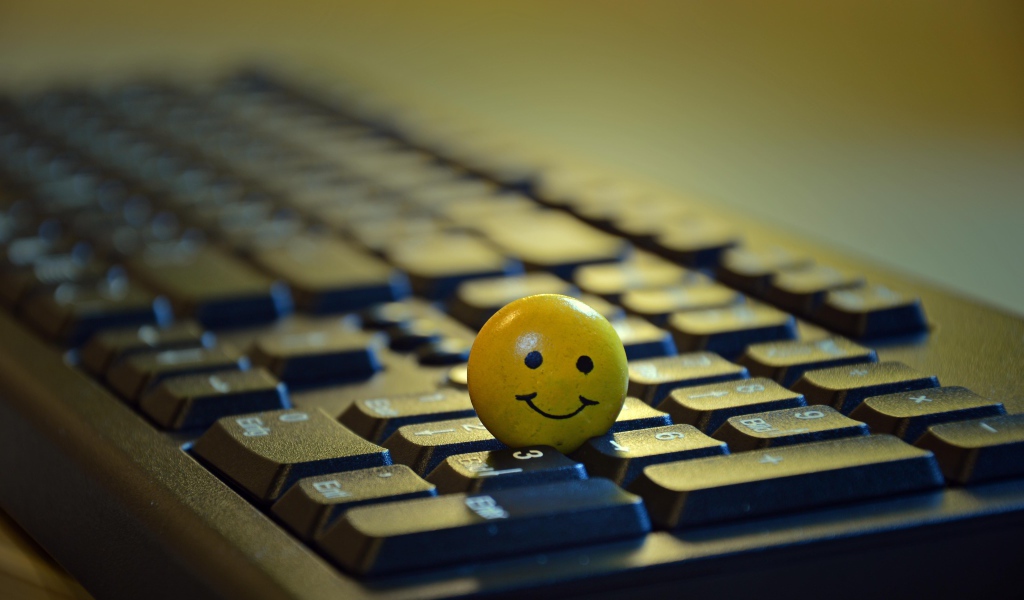 Желтый смайлик на черной клавиатуре 