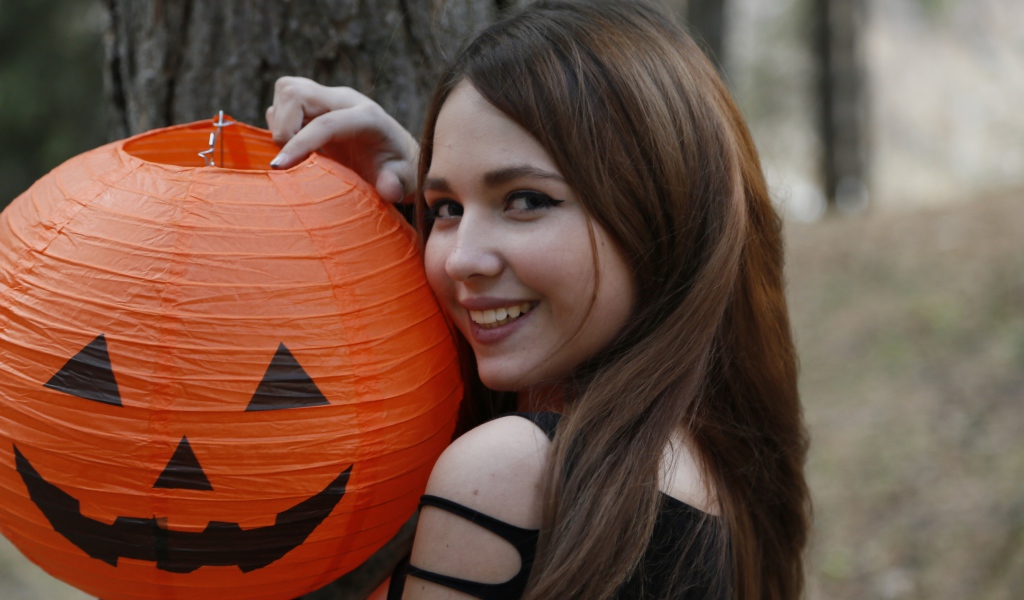 Улыбающаяся девушка с декором на праздник Хэллоуин