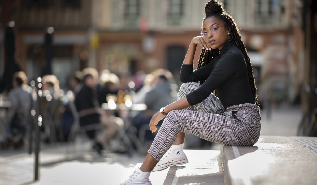 Красивая темнокожая девушка сидит на ступеньках