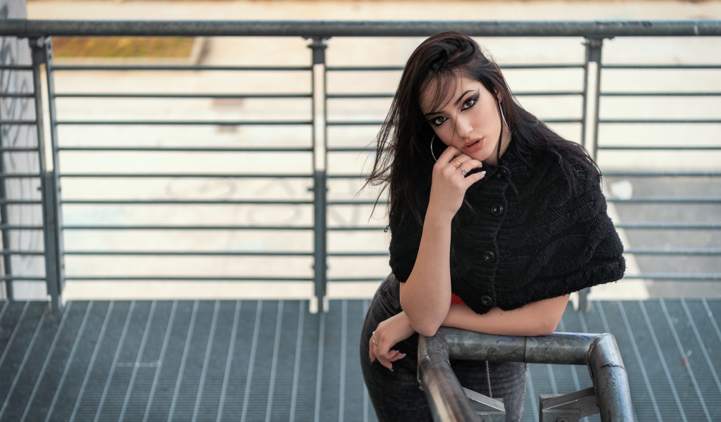 Красивая девушка стоит на ступеньках у перил 