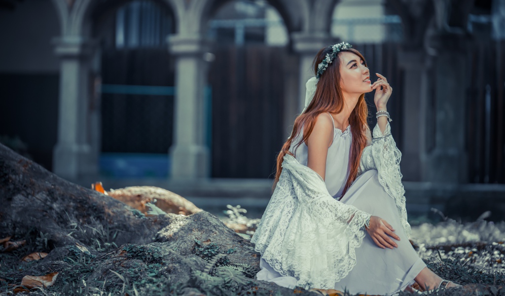 Мечтательная девушка азиатка в белом платье