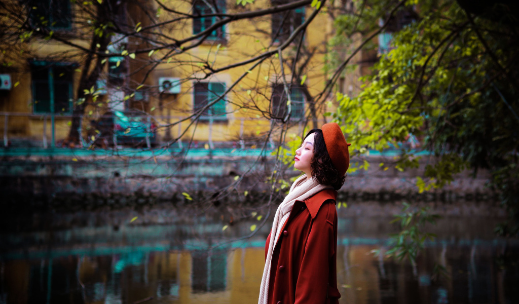 Девушка азиатка в красном пальто у воды