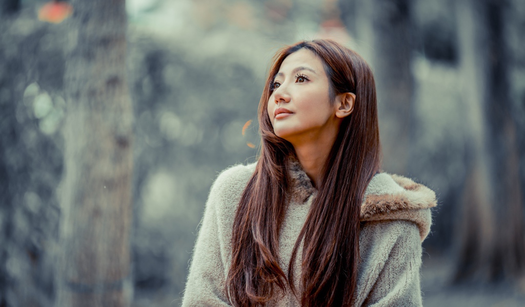 Длинноволосая девушка азиатка смотрит в сторону