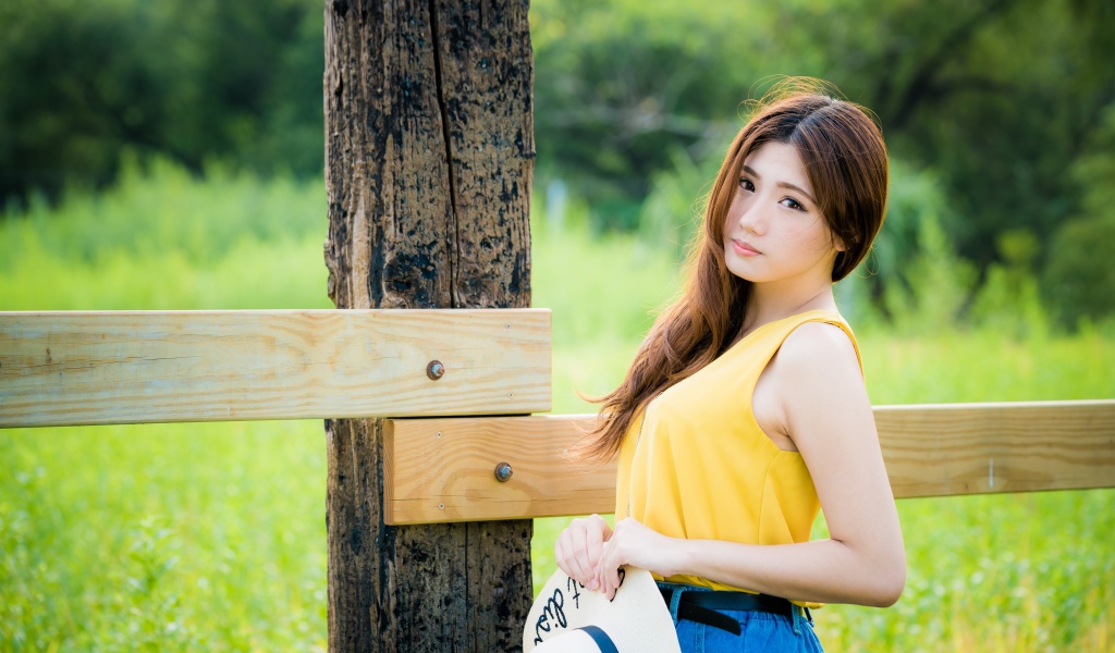 Красивая азиатка у деревянного столба 