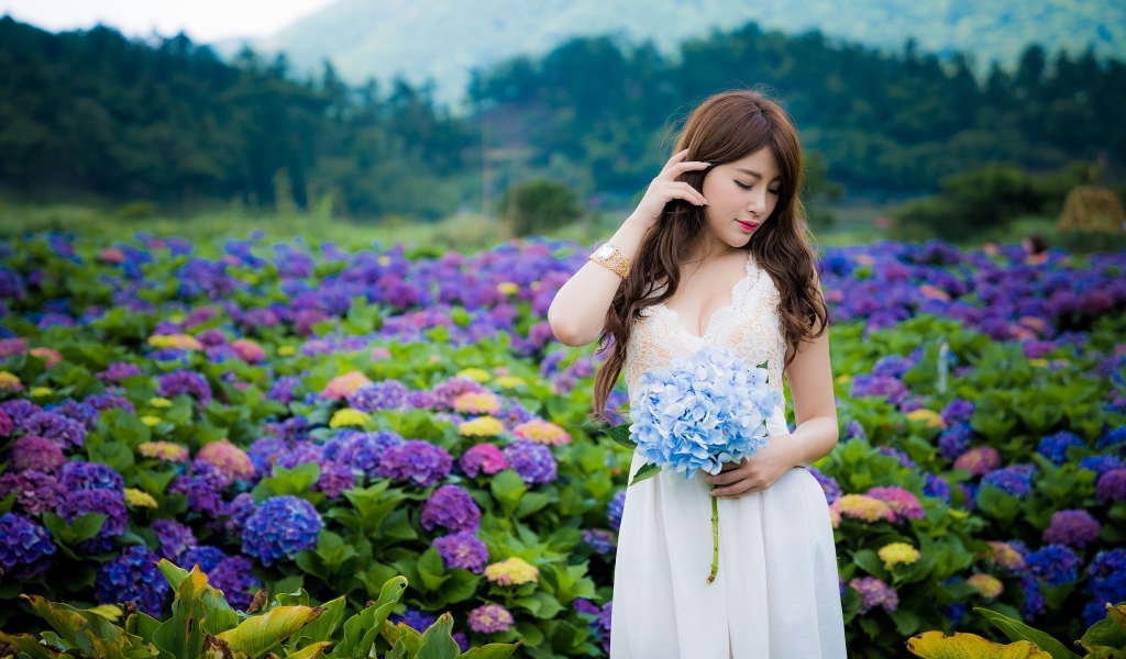 Красивая девушка азиатка в белом платье с цветами гортензии 