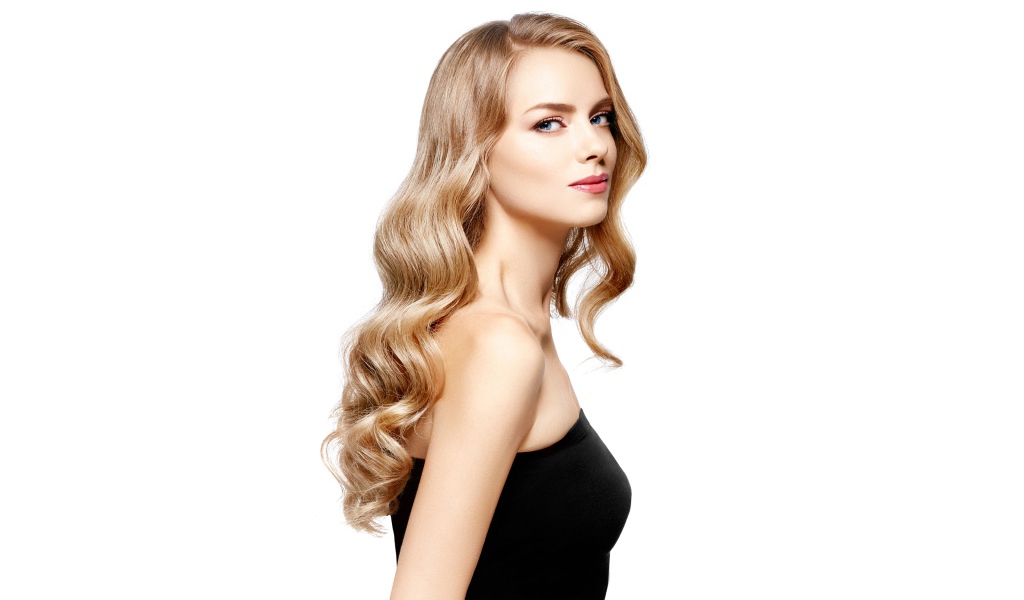 Красивая голубоглазая блондинка в черном наряде на белом фоне