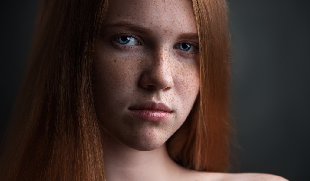 Красивая голубоглазая рыжеволосая девушка с веснушками