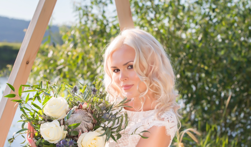 Красивая кареглазая блондинка с букетом в руках 