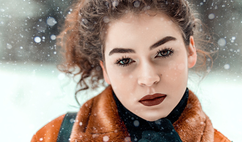 Красивая кареглазая девушка стоит на улице зимой