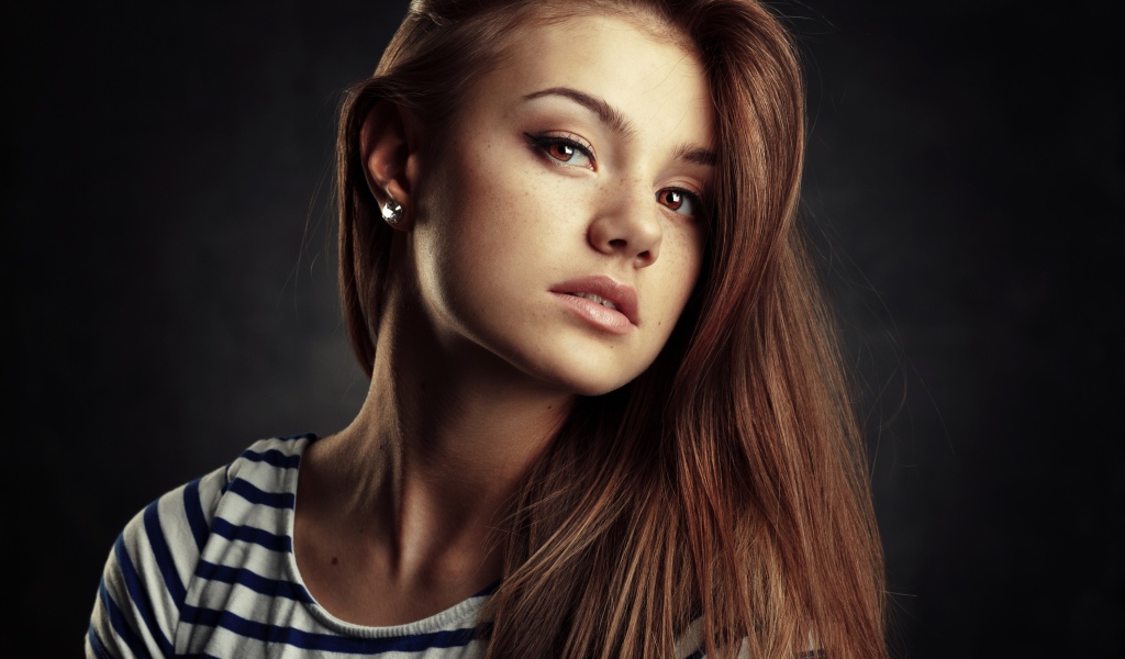 Красивая кареглазая девушка с русыми волосами на сером фоне