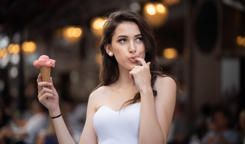 Красивая девушка шатенка с мороженым в руке