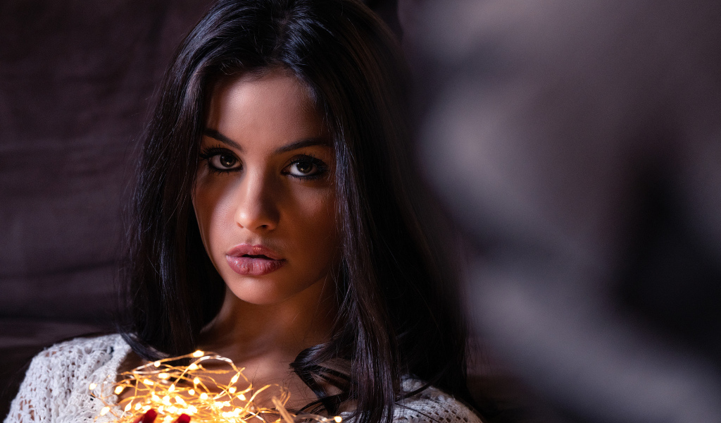 Красивая брюнетка с гирляндой в руках