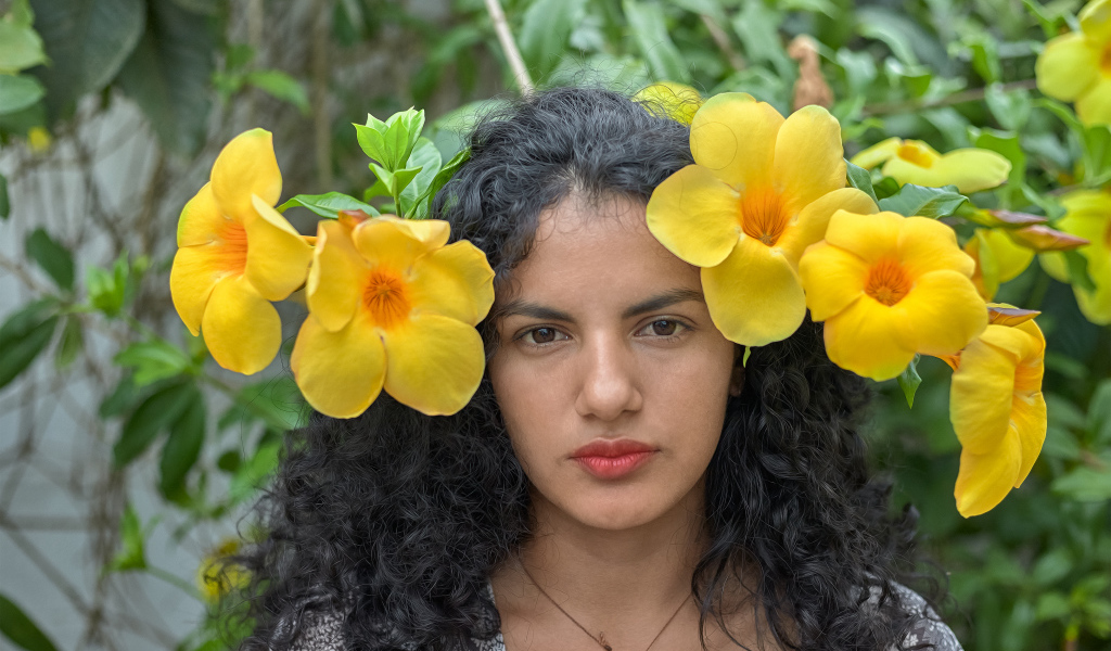 Красивая брюнетка с большими желтыми цветами в волосах 