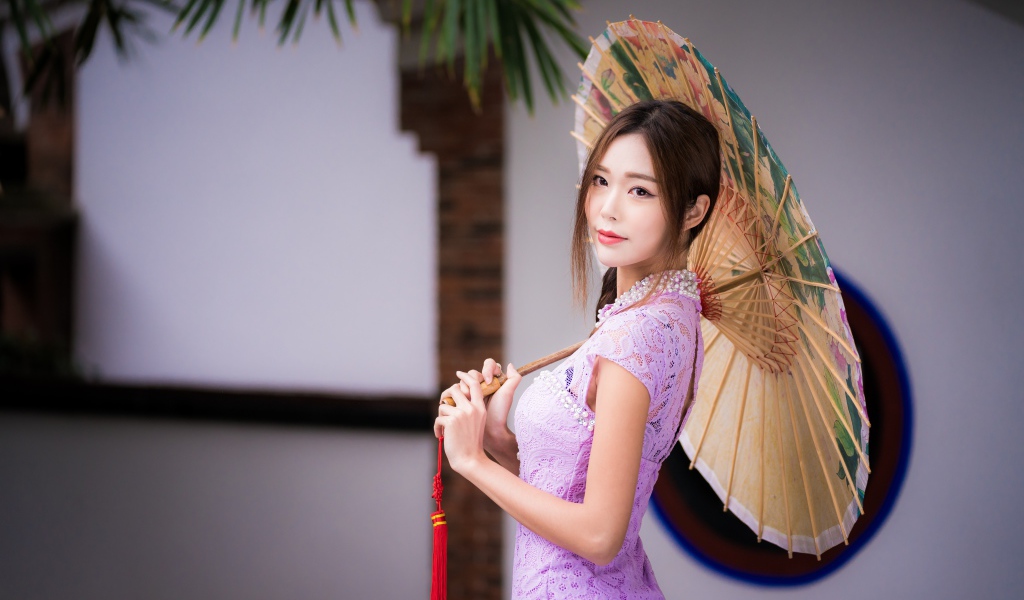Красивая нежная азиатка в сиреневом платье с зонтом в руках