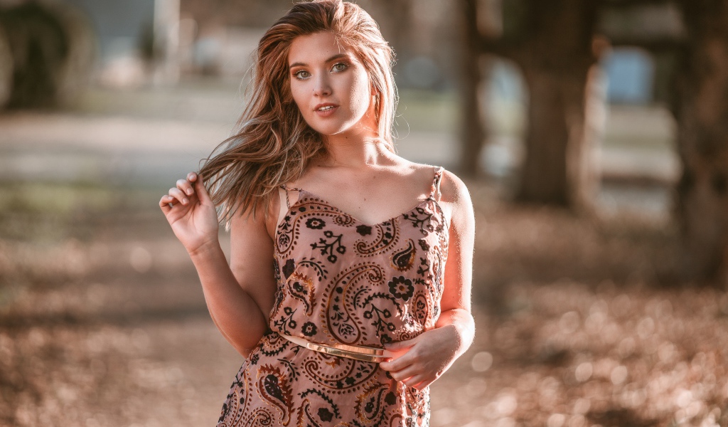 Красивая девушка в платье в лучах солнца летом