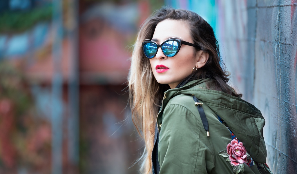 Красивая девушка в куртке и солнечных очках