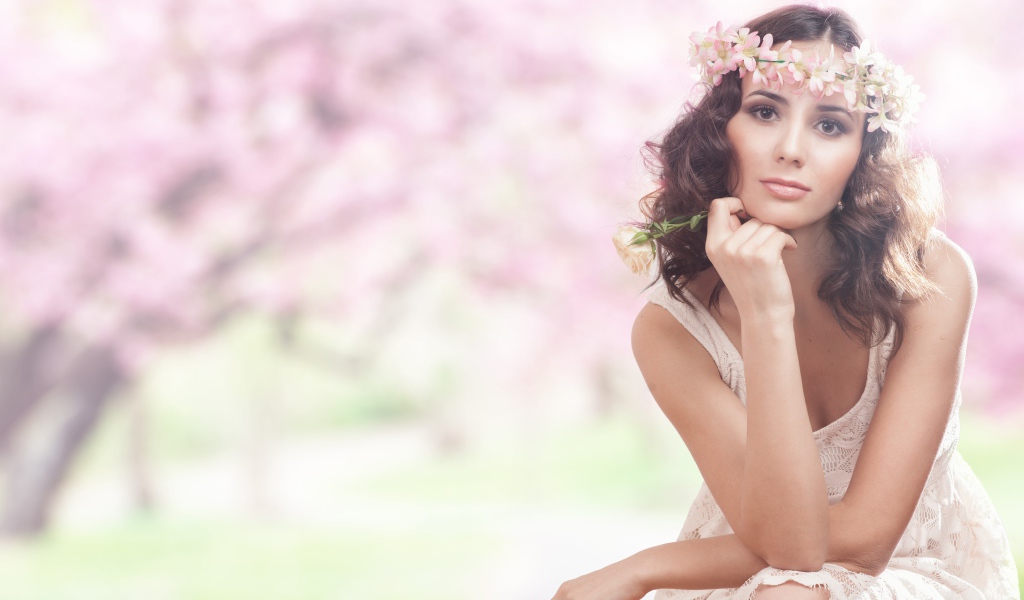 Красивая девушка в розовом платье с венком на голове