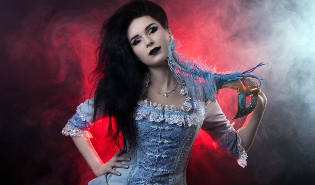 Красивая девушка в старинном платье с маской в руке