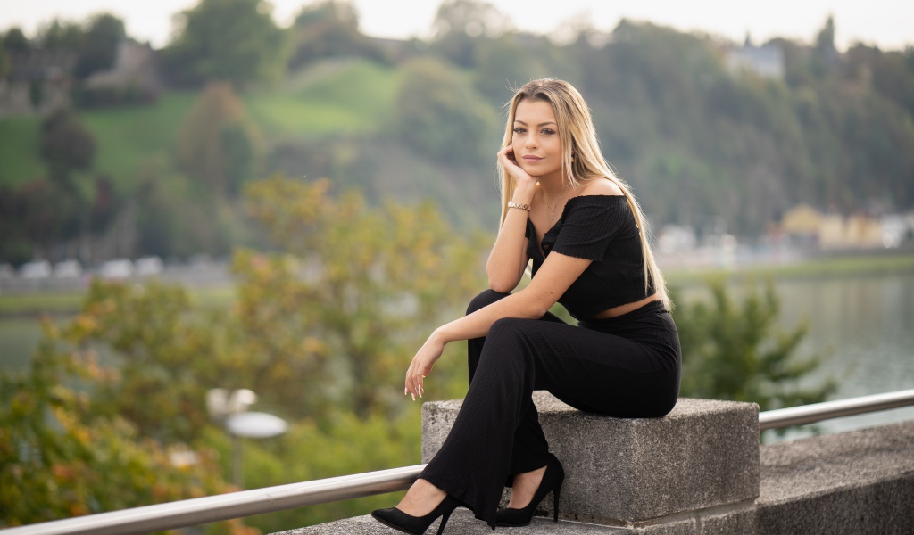 Красивая девушка в черном сидит