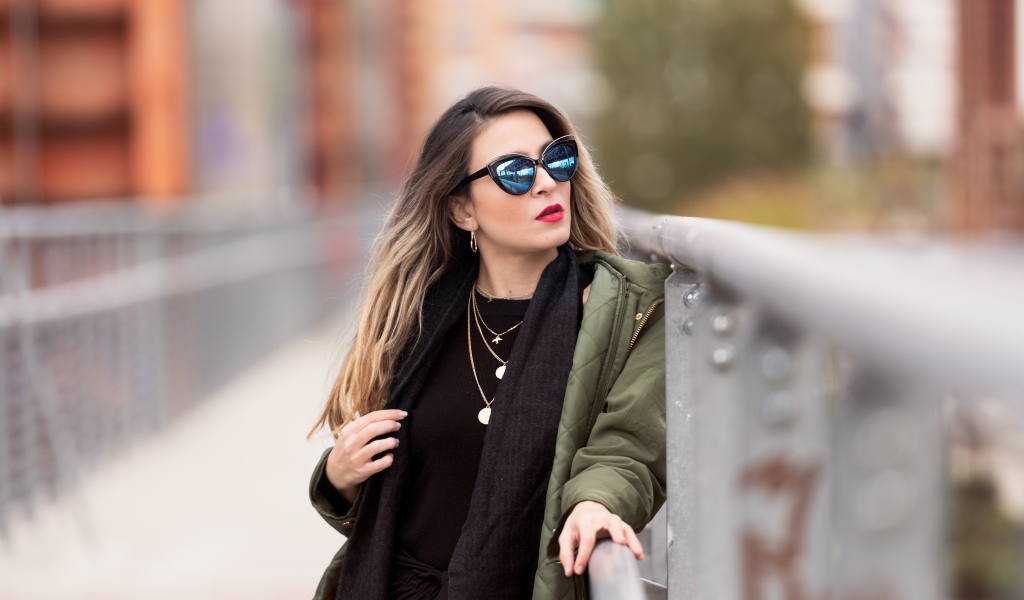 Красивая девушка в солнечных очках на мосту