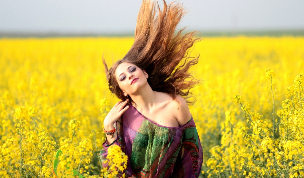 Красивая девушка на поле с желтыми цветами