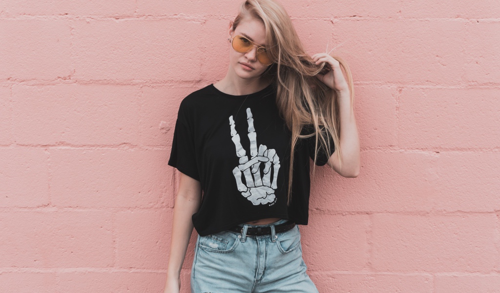 Красивая девушка стоит у розовой стены 