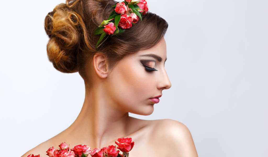 Красивая девушка с прической и венком из роз в волосах 
