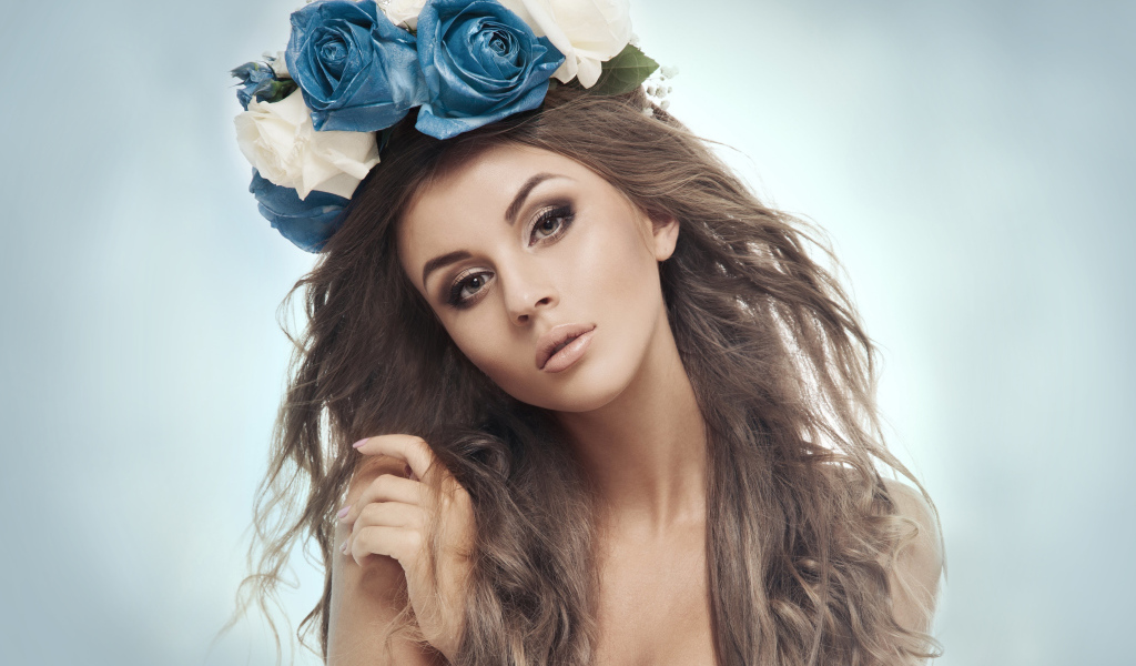 Красивая девушка с венком на голове на сером фоне