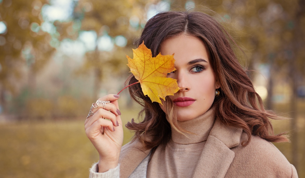 Красивая девушка с осенним листом в руке
