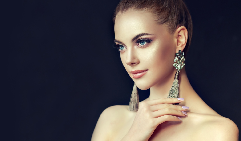 Красивая девушка с серьгами на черном фоне