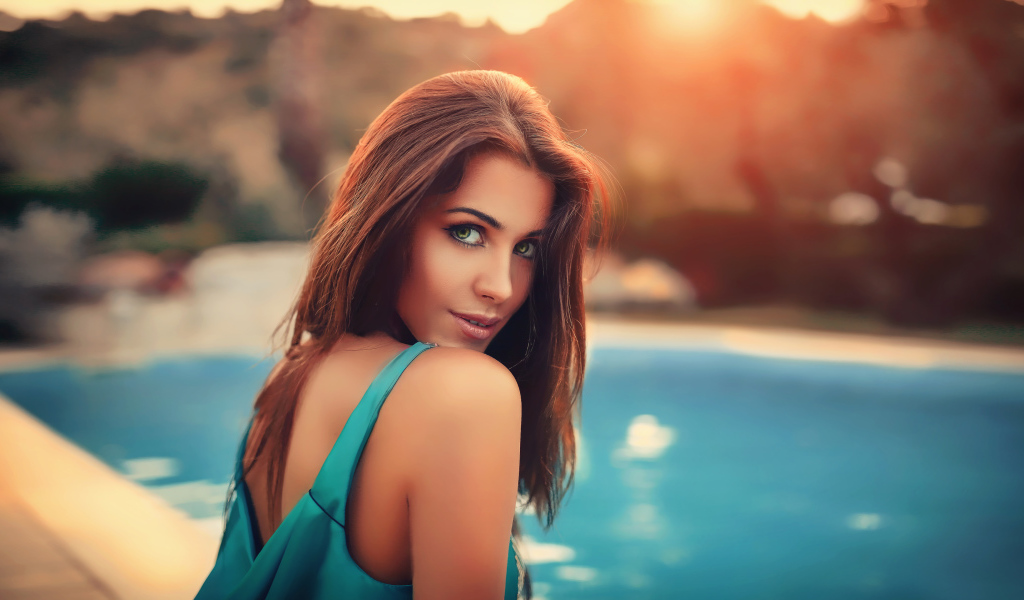 Красивая зеленоглазая шатенка у бассейна