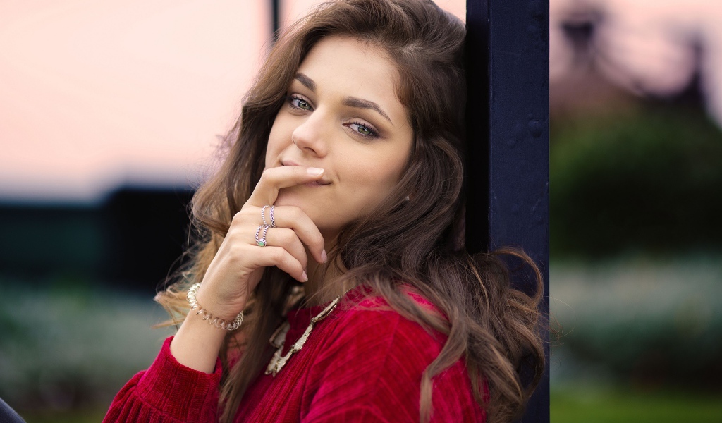 Красивая длинноволосая шатенка с рукой у лица