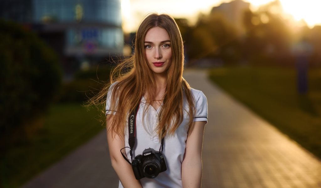 Красивая длинноволосая девушка с фотоаппаратом