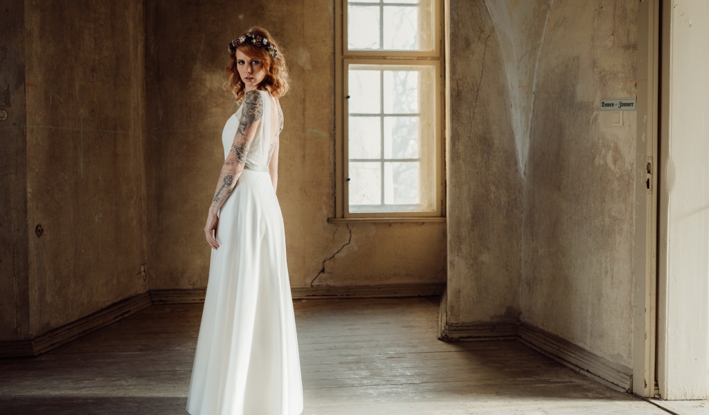 Красивая рыжеволосая девушка в белом платье с  татуировками на теле 