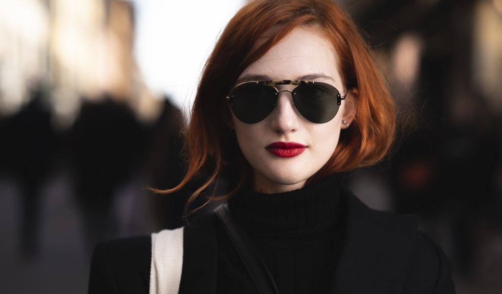 Красивая рыжеволосая девушка в темных очках