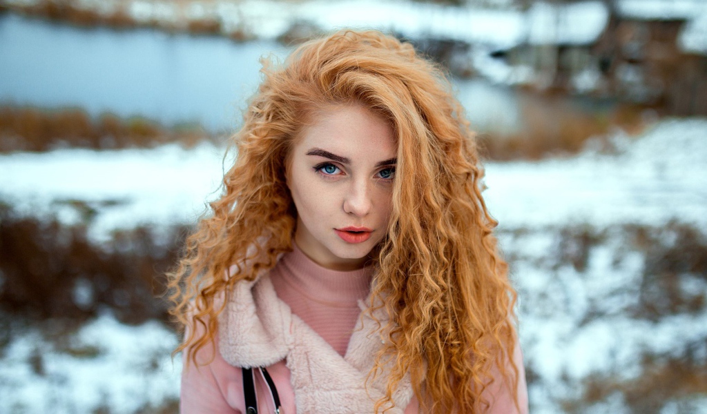 Красивая рыжеволосая девушка с голубыми глазами зимой