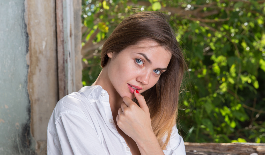 Красивая нежная девушка с серыми глазами с пальцем у рта