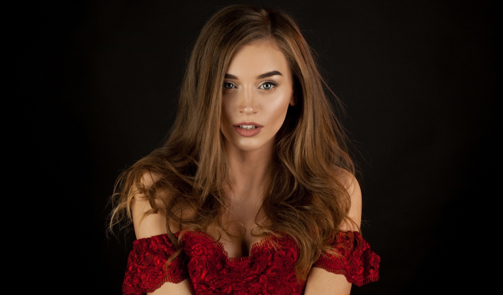 Красивая нежная длинноволосая шатенка в красном платье на черном фоне