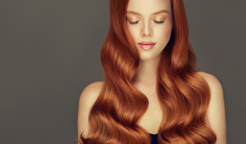 Красивая нежная рыжеволосая девушка на сером фоне