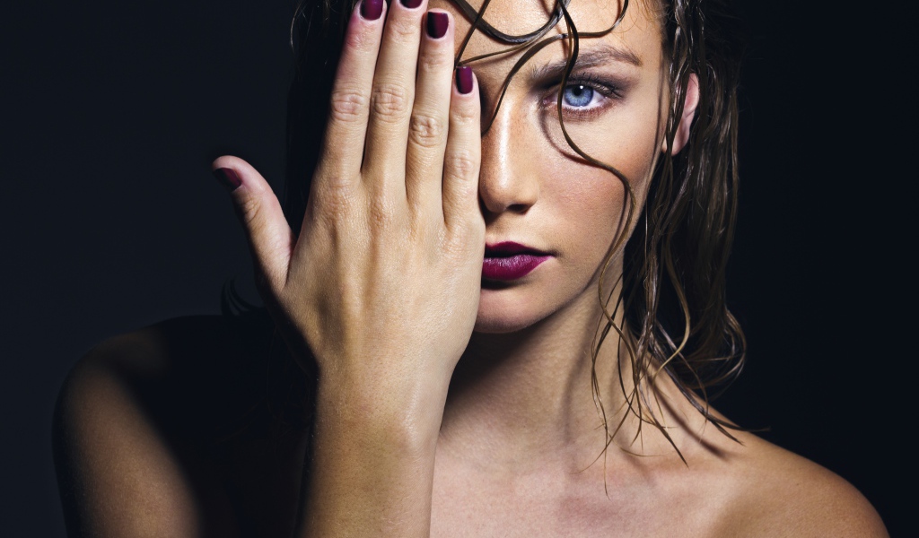 Голубоглазая девушка закрывает лицо рукой